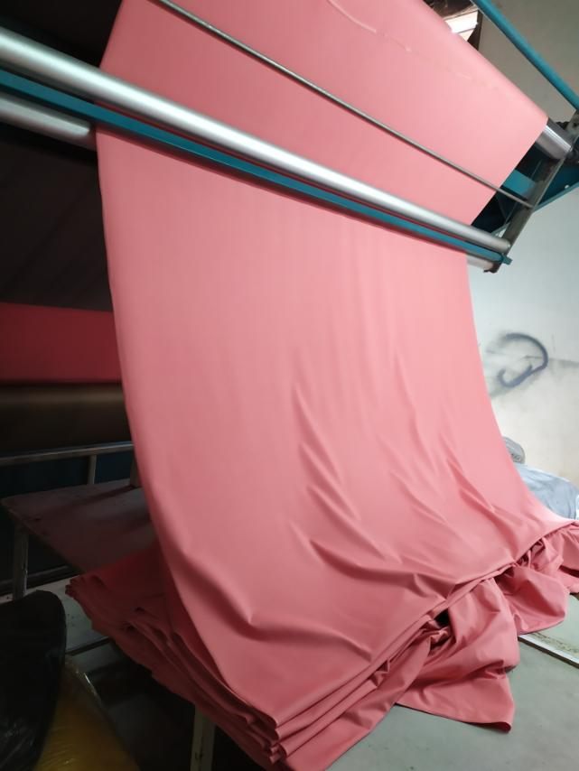 Pink fabric coming off the roller